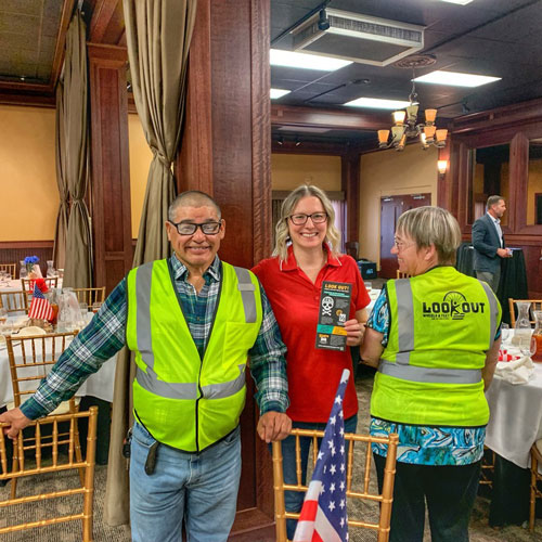 standing with a chamber representative wearing a look out vest