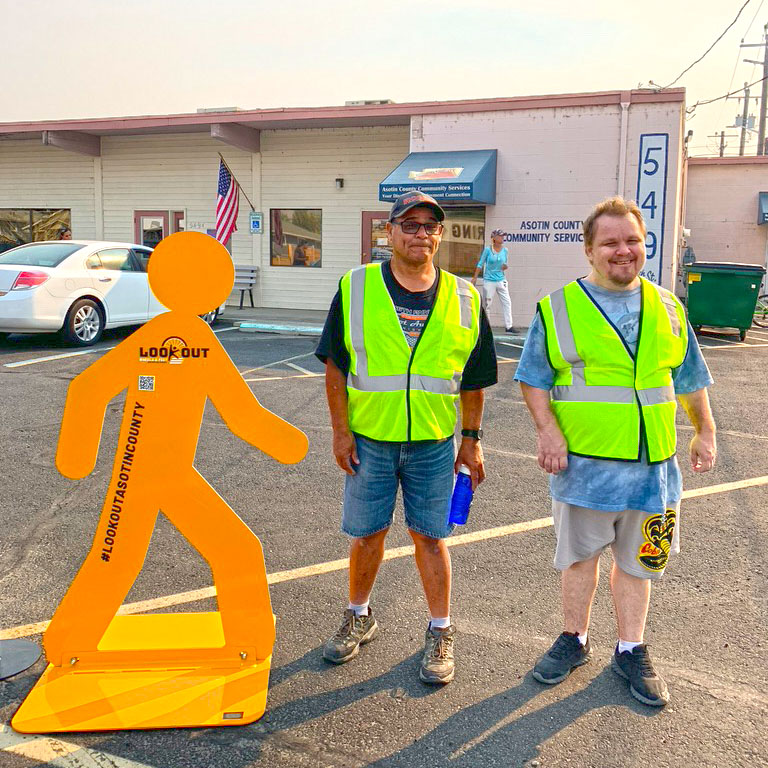 two men standing next to a pedestrian statue